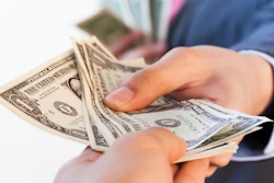 Business Man Giving Bank Notes To Another Person 516934262 2125x1416 (1)