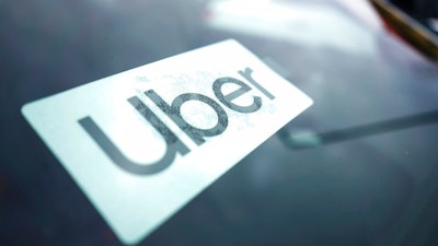 An Uber sign is displayed inside a car in Palatine, Ill., Thursday, Feb. 10, 2022. As Uber pushed into markets around the world, the ride-sharing service lobbied political leaders to relax labor and taxi laws and used a “kill switch″ to thwart regulators and law enforcement. Uber also channeled money through Bermuda and other tax havens and considered portraying violence against its drivers as a way to gain public sympathy. That's according to a report released Sunday by the International Consortium of Investigative Journalists.