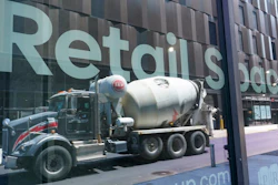 A cement mixer truck reflected on a window at the Essex Crossing development, Manhattan, New York, Aug. 4, 2022.