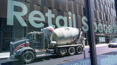 A cement mixer truck reflected on a window at the Essex Crossing development, Manhattan, New York, Aug. 4, 2022.