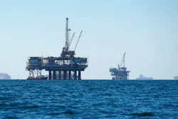 Cargo vessels are anchored offshore near oil platforms, before heading into the Los Angeles-Long Beach port on Oct. 5, 2021. The first official federal calculations of the new spending package that President Biden signed show it will slice America's carbon pollution by more than 1 billion tons by the end of the decade. The new law’s provisions that call for oil and gas leasing on federal land and water “may lead to some increase” in carbon pollution, the federal analysis said.