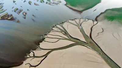 Water flows through channels in the lake bed of Poyang Lake, Aug. 22, 2022.