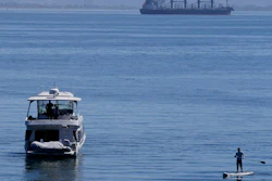 A person paddle boards near a boat in McCovey Cove in San Francisco, Sunday, Sept. 4, 2022.