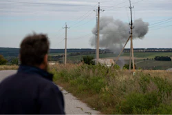 Viktor Lubinets, an agronomist at the Veres farm, looks at smoke following an explosion in Novomykolaivka, Ukraine, Sept. 10, 2022.