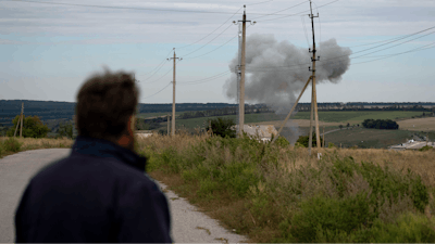 Viktor Lubinets, an agronomist at the Veres farm, looks at smoke following an explosion in Novomykolaivka, Ukraine, Sept. 10, 2022.