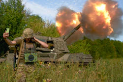 A Ukrainian soldier takes a selfie as an artillery system fires in the front line in Donetsk region, eastern Ukraine, Saturday, Sept. 3, 2022.