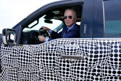 President Joe Biden stops to talk to the media as he drives a Ford F-150 Lightning truck at Ford Dearborn Development Center, May 18, 2021, in Dearborn, Mich. Biden, a self-described “car guy,'' often promises to lead by example by moving swiftly to convert the sprawling federal fleet to zero-emission electric vehicles.