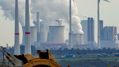 Steam comes out of the chimneys of the coal-fired power station Neurath near the RWE Garzweiler open-cast coal mine in Luetzerath, Germany, Monday, Oct.25, 2021.