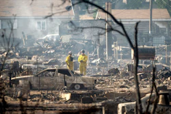 Firefighters survey homes on Wakefield Avenue destroyed by the Mill Fire on Saturday, Sept. 3, 2022, in Weed, Calif.