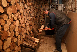Tudor Popescu chops fire wood he uses for heating in a storage room attached to his home in Chisinau, Moldova, Saturday, Oct. 15, 2022.