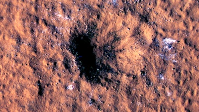 In this image made available by NASA on Thursday, Oct. 27, 2022, boulder-size blocks of water ice are seen around the rim of an impact crater on Mars, as viewed by the High-Resolution Imaging Science Experiment (HiRISE camera) aboard NASA's Mars Reconnaissance Orbiter. The crater was formed Dec. 24, 2021, by a meteoroid strike in the Amazonis Planitia region.
