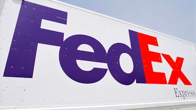 The FedEx logo is seen on a delivery truck, Tuesday, June 21, 2011, in Springfield, Ill. On Monday, Oct. 17, 2022, a federal judge dismissed FedEx from a lawsuit filed by relatives of five of the eight people who were fatally shot last year at an Indianapolis warehouse by a former employee of the shipping giant.