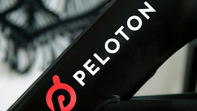 This Nov. 19, 2019 photo shows a Peloton logo on the company's stationary bicycle in San Francisco, Calif. Peloton told employees Thursday, Oct. 6, 2022, that it will cut approximately 500 jobs, or about 12% of its workforce, as post- pandemic sales of its indoor exercise equipment continues to tail off.