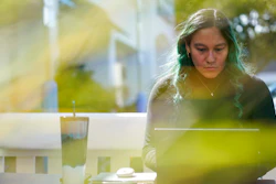 Daniella Malave works on her laptop at a coffee shop in Sea Girt, N.J., Thursday, Sept. 29, 2022. While working full time for Chipotle, Malave completed two years of community college with annual stipends of $5,250 from the restaurant chain. After that, she enrolled in the company’s free online college program, through which she earned a bachelor’s degree in business management from Wilmington University in 2020.