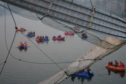 Rescuers on boats search in the Machchu river next to a cable suspension bridge that collapsed in Morbi town of western state Gujarat, India, Monday, Oct. 31, 2022.
