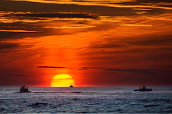 Lobster fishermen work at sunrise in the Atlantic Ocean, Sept. 8, 2022, off of Kennebunkport, Maine.