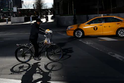 A man making deliveries rides an electronic bike in New York, Dec. 21, 2017.