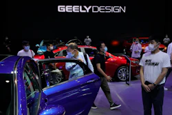 Visitors look at cars produced by Geely at the Auto China 2020 show in Beijing on Sept. 27, 2020.