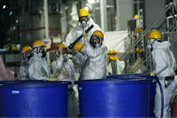 Men in hazmat suits work inside a facility with equipment to remove radioactive materials from contaminated water at the Fukushima Daiichi nuclear power plant, run by Tokyo Electric Power Company Holdings (TEPCO), in Okuma town, northeastern Japan, Thursday, March 3, 2022.