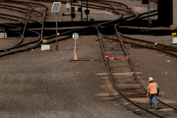 A worker walks along tracks at a BNSF rail yard in Kansas City, Kan., Sept. 14, 2022.