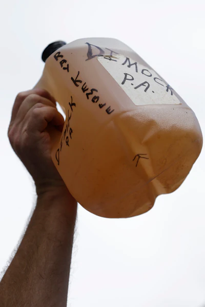 Ray Kemble of Dimock, Pa., protests hydraulic fracturing outside a Marcellus Shale industry conference as he holds a jug of well water, on Sept. 20, 2012, in Philadelphia. Residents of Dimock, a rural community whose drinking water has been contaminated for 14 years met, Monday, Nov. 21, 2022, with high-level officials in the Pennsylvania attorney general’s office, a clear indication of movement in the state’s long-running criminal case against a gas driller charged with polluting the aquifer.
