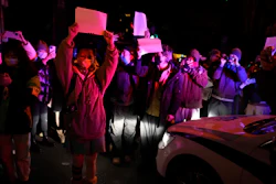 Protesters hold up blank papers and chant slogans as they march in protest in Beijing, Sunday, Nov. 27, 2022.