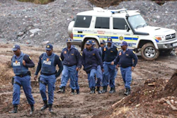 South African police investigate at the scene where more than 20 bodies, suspected of being illegal miners, were found near an active mine in Krugersdorp, South Africa, Thursday, Nov. 3, 2022. Police suspect that the bodies were moved to where they were found at a privately-owned mine. The grim discovery is the latest in a series of incidents related to illegal mining in the Krugersdorp area.