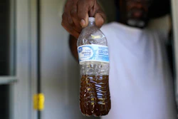 Toney Lewis shows a bottle of tap water he saved, before his neighborhood was recently switched to the current Ferriday, La. water system, in Ridgecrest, La., Tuesday, Sept. 13, 2022.