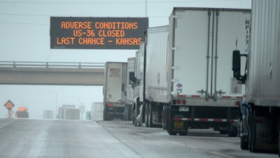 Tractor-trailers stacked up along eastbound lanes of Interstate 70 near East Airpark Road, Aurora, Colo., Dec. 13, 2022.