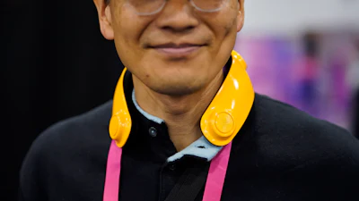 Exhibitor Toru Yamanaka wears a Loovic augmented reality device during CES Unveiled before the start of the CES tech show, Tuesday, Jan. 3, 2023, in Las Vegas. The IoT device, worn around the neck, uses tactile notifications and bone conduction audio to help guide the user without having to constantly look at a map app on their phone.