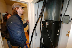 John Paul, front, and David Valenzuela work to install a heat pump in an 80-year-old rowhouse Friday, Jan. 20, 2023, in northwest Denver.