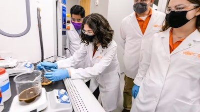 The authors with two students show methods for recycling bio-based foam.