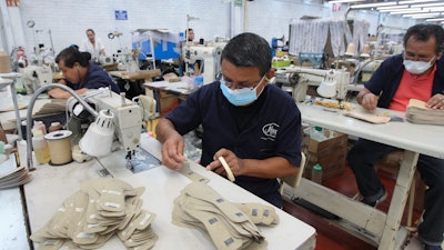 A man works in a shoe maquiladora or factory, in Leon, Mexico, Monday, Feb. 7, 2023.