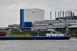 A container ship passes the Ford car plant in Cologne, Germany, May 4, 2020.