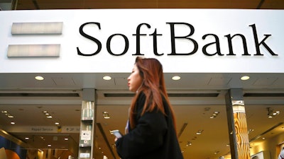 A woman walks in front of SoftBank store in Ginza shopping district in Tokyo, Jan. 20, 2020. Japanese investor SoftBank Group reported Tuesday, Feb. 7, 2023 that it sank into a deep loss for the October-December quarter, slammed by the global plunge in technology shares.