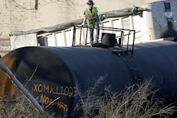 A cleanup worker stands on a derailed tank car of a Norfolk Southern freight train in East Palestine, Ohio, Feb. 15, 2023.