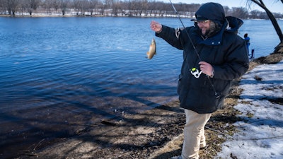 Tyler Abayare catches a red horse carp on the Mississippi River at the Montissippi County Park downriver from the Xcel Energy nuclear power plant in Monticello, Minn., on Friday, March 24, 2023. Abayare fishes at this spot everyday and noticed increased activity including people taking water samples around three times a week in the last 60 days.