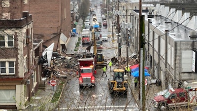 Emergency responders and heavy equipment are seen at the site of a deadly explosion at a chocolate factory in West Reading, Pennsylvania, Saturday, March 25.