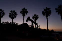 A pump jack sits idle in front of palm trees on June 9, 2021, in Signal Hill, Calif.