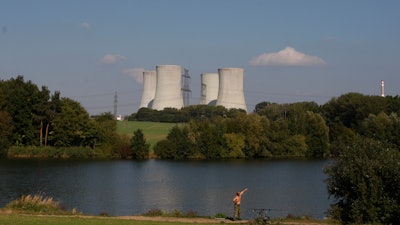 A man fishes with the towering Dukovany nuclear power plant in the background, in Dukovany, Czech Republic, Sept.. 27, 2011. The Czech Republic’s major power company signed a deal on Wednesday, March 29, 2023 with U.S. Westinghouse Electric Co. to deliver fuel supplies for the Dukovany nuclear plant, erasing the country’s dependence on Russia.