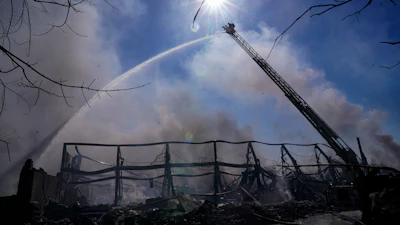 Firefighters pour water on an industrial fire in Richmond, Ind., Thursday, April 13, 2023.