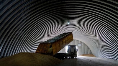 A dump track unloads grain in a granary, Zghurivka, Ukraine, Aug. 9, 2022.