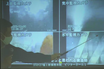 A spokesperson of the Tokyo Electric Power Company Holdings (TEPCO) shows photos captured by a robotic probe inside one of the three melted reactors at the tsunami-wrecked Fukushima nuclear power plant, during a news conference at the TEPCO headquarters in Tokyo, Tuesday, April 4, 2023. Those robotic images showed exposed steel bars in the main supporting structure and its thick external concrete wall largely missing near its bottom, triggering concerns about its earthquake resistance in case of another major disaster.