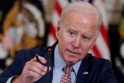 President Joe Biden adjusts his microphone during a meeting with the President's Council of Advisors on Science and Technology in the State Dining Room of the White House, Tuesday, April 4, 2023, in Washington.