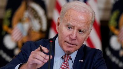 President Joe Biden adjusts his microphone during a meeting with the President's Council of Advisors on Science and Technology in the State Dining Room of the White House, Tuesday, April 4, 2023, in Washington.