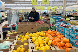 A man looks at his mobile phone while shopping at a grocery store in Buffalo Grove, Ill., March 19, 2023.