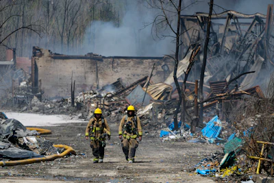 Firefighters walk out of the site of an industrial fire in Richmond, Ind., Wednesday, April 12, 2023.