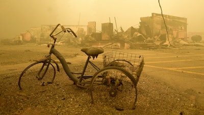 A trike stands near the burnt remains of a building destroyed by a wildfire near the Lake Detroit Market in Detroit, Ore., Sept. 11, 2020.