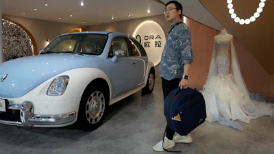 A visitor stands near a display of a car from Ora at the Auto Shanghai 2023 show in Shanghai, Wednesday, April 19, 2023.