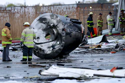 Investigators from the State Fire Marshal's Office examine a vat that was hurled out of the pharmaceutical plant and landed an estimated 30 feet away in Newburyport, Mass., Thursday, May 4, 2023.